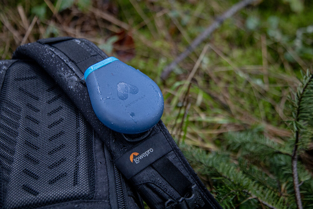 The Global Hotspot clipped to a backpack strap.